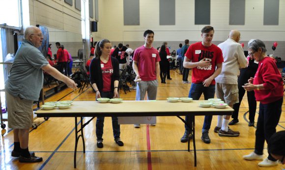 SEBS student Linda Dragun, at left, and colleagues Saige Gomez and Morris Kim play a game of modified pong with the senior citizens. 