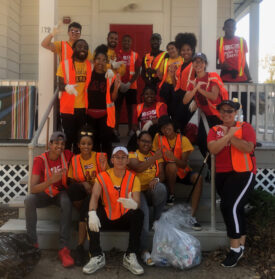 Rutgers student volunteers posing on steps on clean-up day.