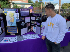 Luis Gasca in front of a booth with information on domestic violence