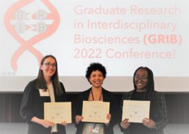 Three graduate students holding awards for poster competition