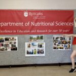 A person standing next to a banner that says, 'Department of Nutritional Sciences'.