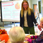 A person delivering a presentation to seniors