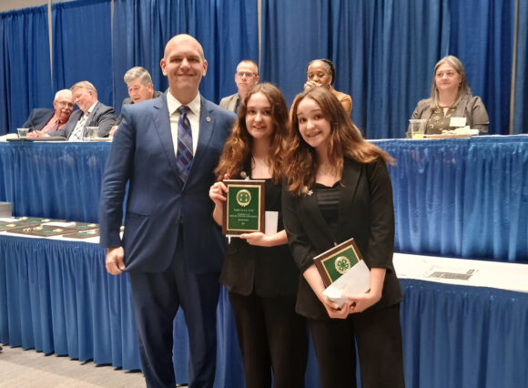 Individuals pose with an award