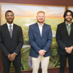 Three individuals post for a picture