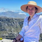 a person is photographed outdoors wearing a wide-brimmed hat