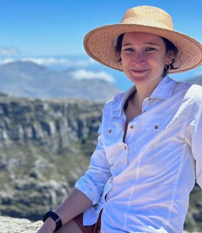 a person is photographed outdoors wearing a wide-brimmed hat