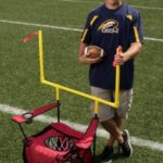 A person standing with a football game that he invented