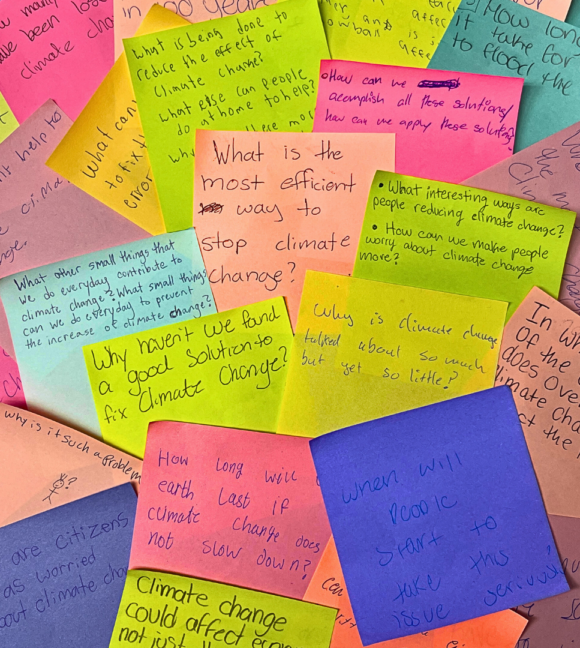 Several colorful post-its in a pile. All have a question about climate change. Prominently featured are the questions: What is the most efficient way to stop climate change? Why haven’t we found a good solution to fix climate change? Why is climate change talked about so much but yet so little? When will people start to take this issue seriously?