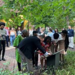 Brian McGonigle with Sophia Modu DC'89, and family, affixing the namplace for Chi Modu CC'89 to the Rutgers Rising plaque.