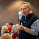 A person holding a microphone and speaking