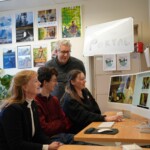 Four people sitting around a computer