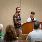 Two presenters speak to a group