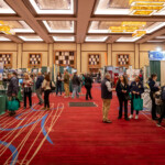 An image of a convention with many booths about agriculture and people walking around from booth to booth