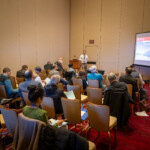 A speaker asks the audience if they have questions