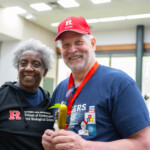Two people posing for a picture together while one holds a pickle