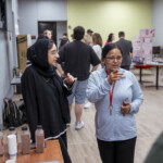 A member of the Food Science Faculty conversing with student about their project