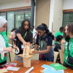 STEM Amb 2025 Newsroom Article - 2 Four people attempt a design challenge together