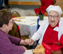 Two people speaking and holding hands